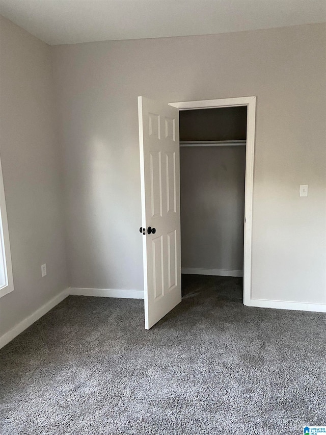 spare room featuring dark colored carpet