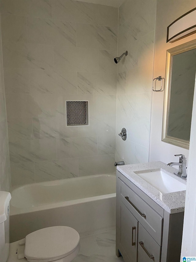 full bathroom with tiled shower / bath, vanity, and toilet