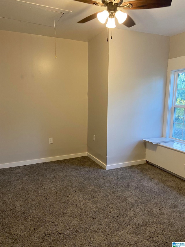 spare room with ceiling fan and dark colored carpet