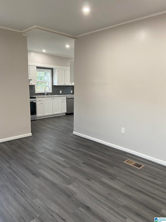 unfurnished living room featuring crown molding, sink, and dark wood-type flooring