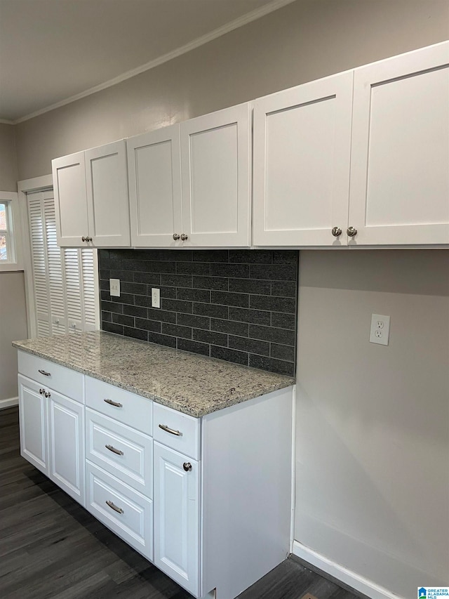 kitchen with white cabinets, light stone countertops, dark hardwood / wood-style floors, and tasteful backsplash