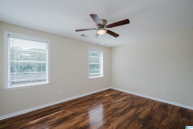 unfurnished room with a healthy amount of sunlight, ceiling fan, and dark hardwood / wood-style floors