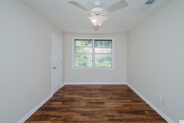 spare room featuring dark wood-type flooring and ceiling fan