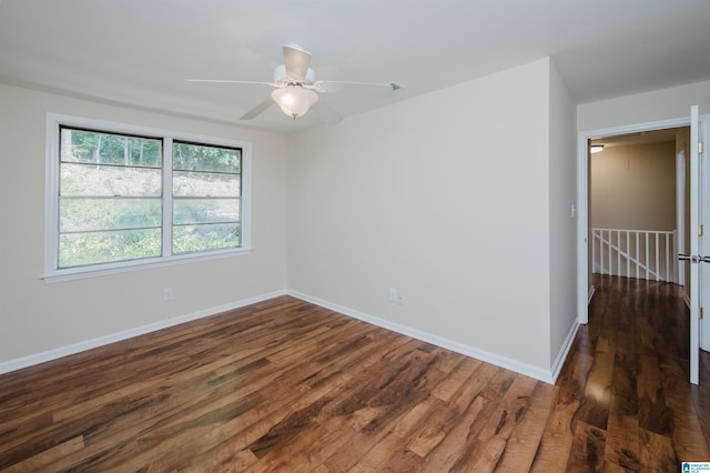 spare room featuring dark wood-type flooring and ceiling fan