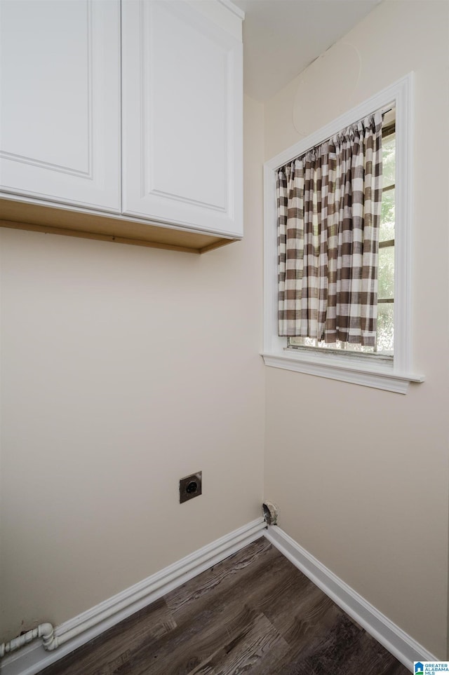 clothes washing area with cabinets, hookup for an electric dryer, and dark hardwood / wood-style flooring