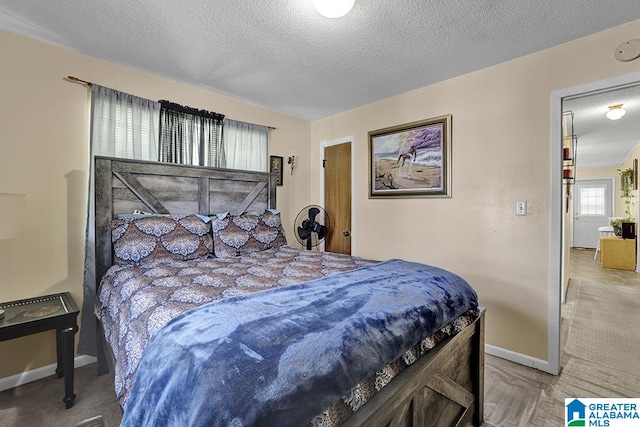 bedroom featuring light carpet and a textured ceiling