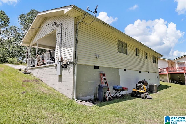 back of house with central AC unit and a lawn