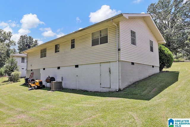 rear view of house featuring central AC and a lawn