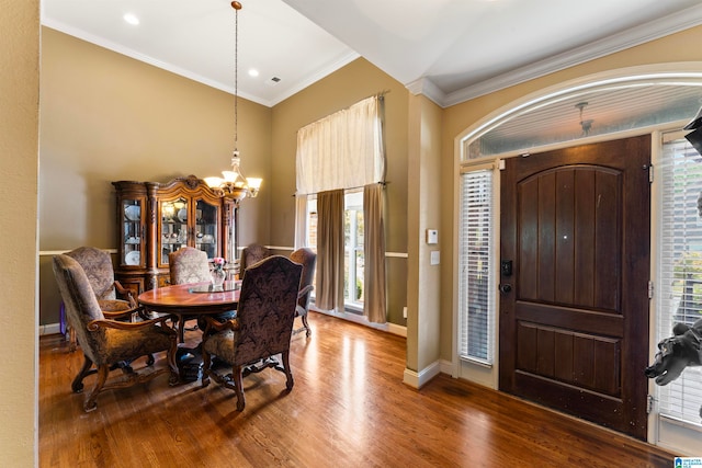 entryway featuring crown molding, wood-type flooring, and an inviting chandelier