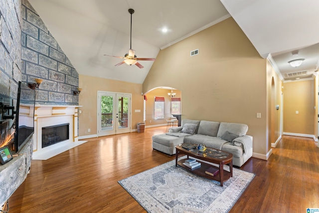 living room featuring ceiling fan, hardwood / wood-style flooring, high vaulted ceiling, ornamental molding, and a fireplace