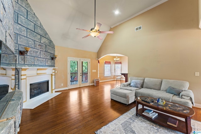 living room featuring ornamental molding, hardwood / wood-style floors, high vaulted ceiling, and a large fireplace