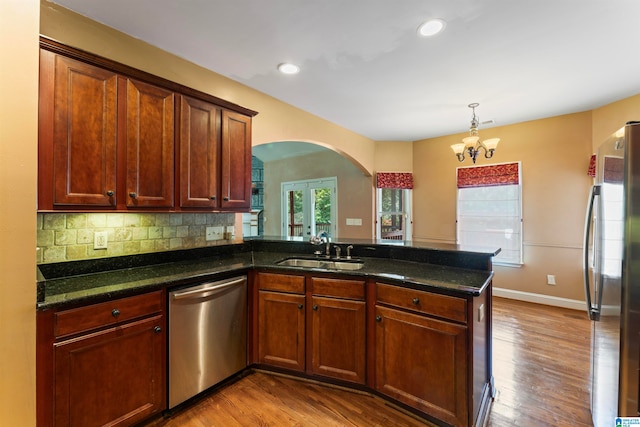 kitchen featuring light hardwood / wood-style flooring, appliances with stainless steel finishes, sink, and kitchen peninsula