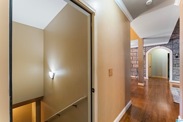 hall with crown molding, dark wood-type flooring, and vaulted ceiling