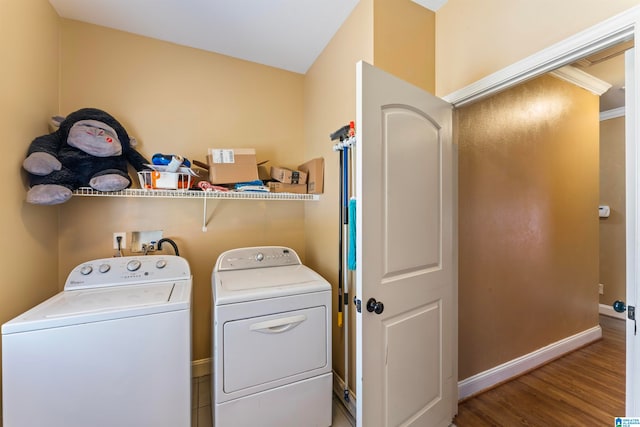 washroom featuring hardwood / wood-style floors, crown molding, and separate washer and dryer