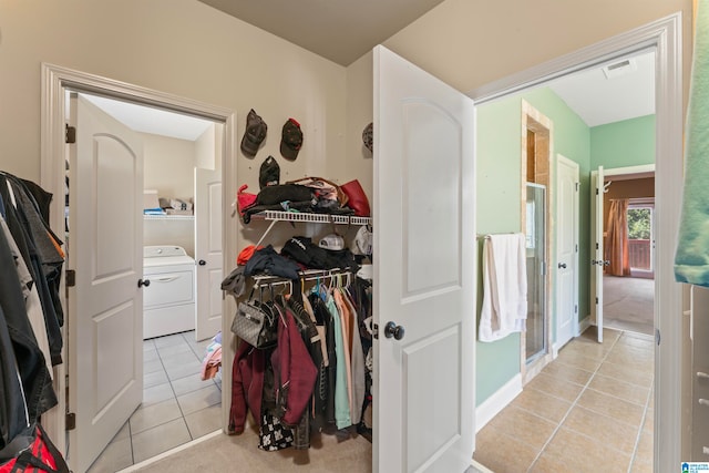 bathroom featuring washer / dryer, tile patterned flooring, and an enclosed shower