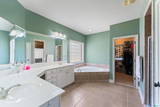 bathroom with vanity, tiled tub, and tile patterned flooring