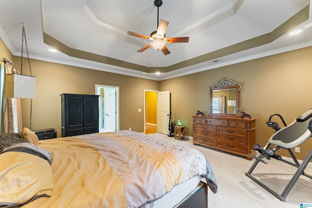 bedroom with crown molding, a tray ceiling, carpet, and ceiling fan