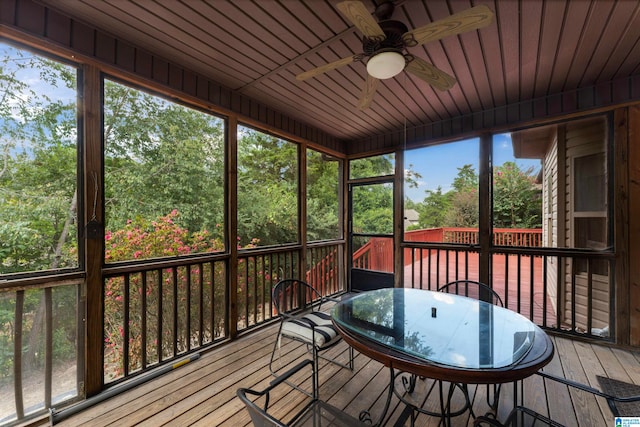 unfurnished sunroom featuring wood ceiling and ceiling fan