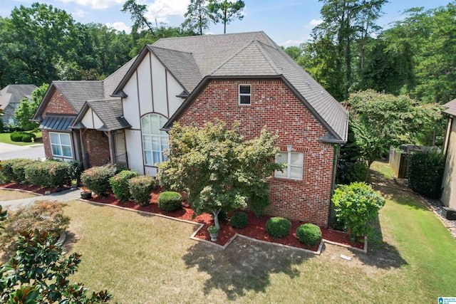 tudor-style house featuring a front lawn