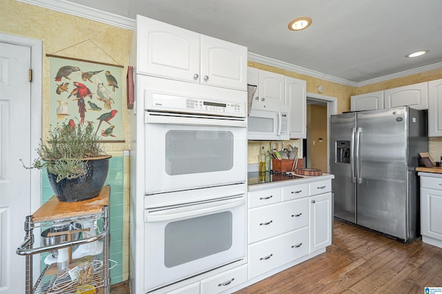 kitchen featuring dark hardwood / wood-style floors, white cabinets, decorative backsplash, white appliances, and ornamental molding