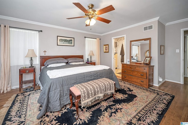 bedroom with connected bathroom, ornamental molding, hardwood / wood-style floors, and ceiling fan