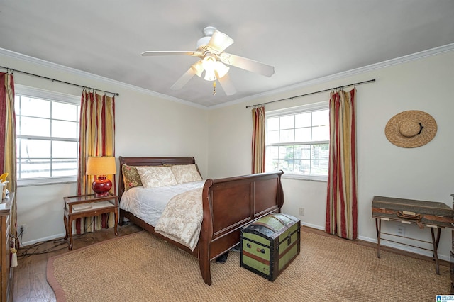 bedroom featuring multiple windows, crown molding, wood-type flooring, and ceiling fan