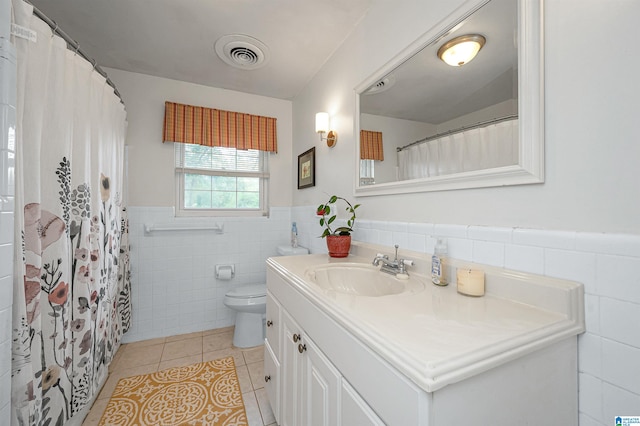 bathroom featuring vanity, tile walls, toilet, and tile patterned floors