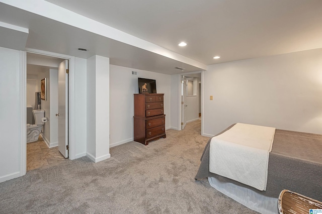 bedroom featuring light carpet and ensuite bathroom