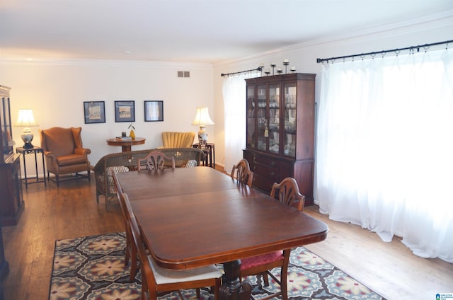 dining space featuring dark hardwood / wood-style floors and crown molding