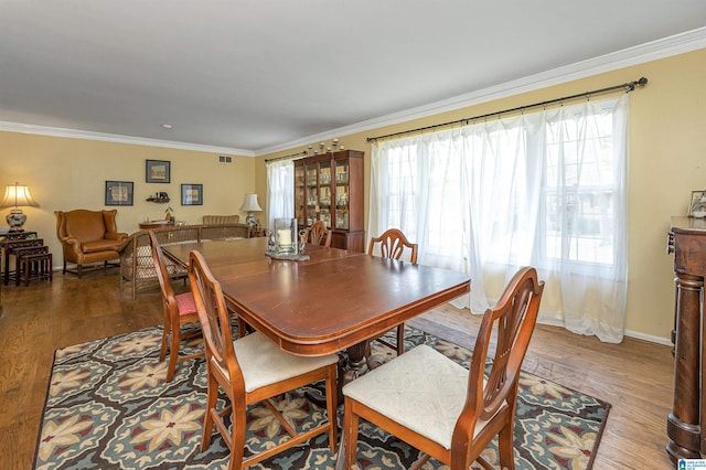 dining room featuring hardwood / wood-style flooring and crown molding