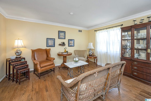 living area with wood-type flooring and crown molding