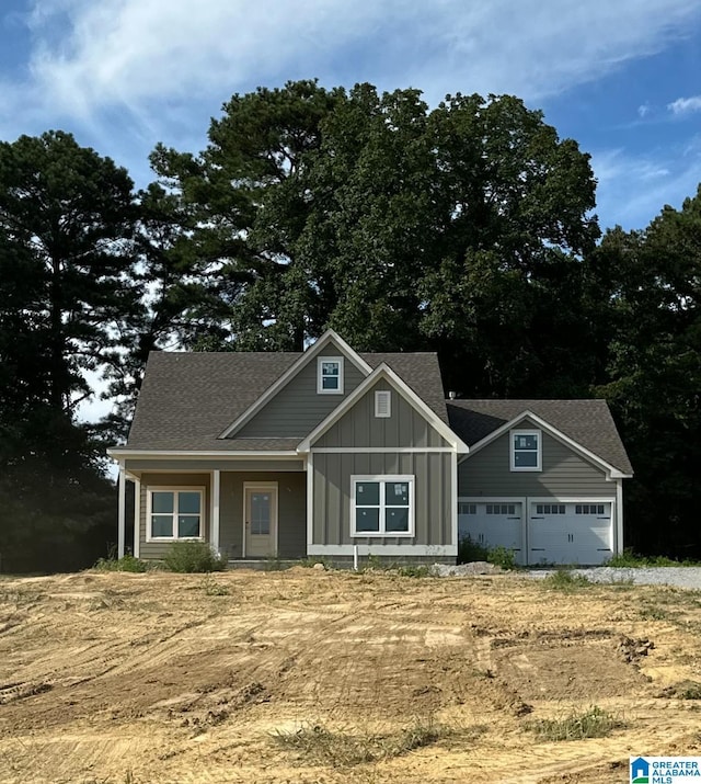 craftsman inspired home with roof with shingles, board and batten siding, and an attached garage