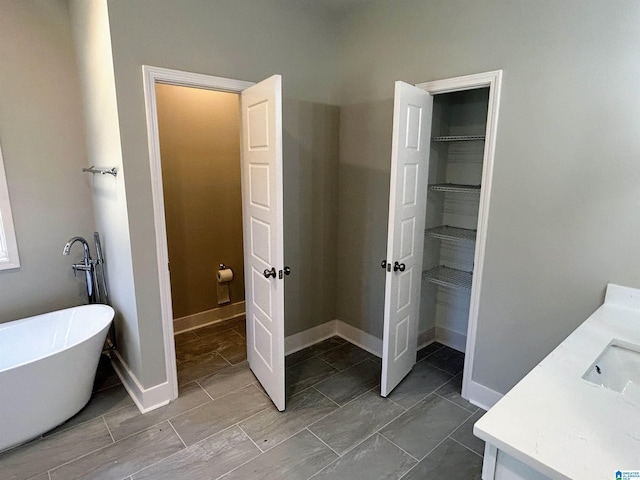 1465 Brooks Dr, Mount Olive, AL 35117 - full bath featuring vanity, a freestanding tub, a spacious closet, and baseboards