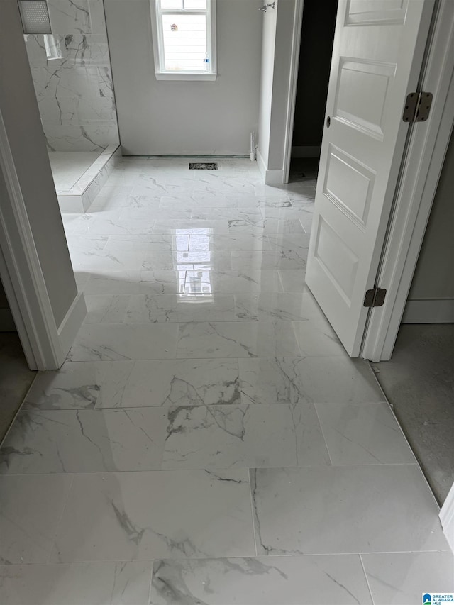 full bath with marble finish floor and a stall shower