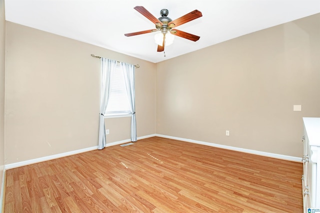 empty room with light wood finished floors, baseboards, and a ceiling fan