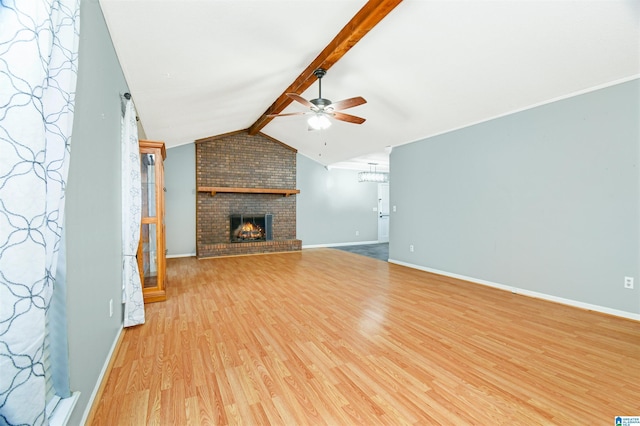 unfurnished living room with lofted ceiling with beams, ceiling fan, a fireplace, baseboards, and light wood finished floors