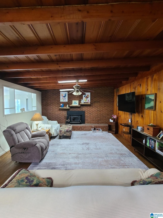 living room featuring beam ceiling, brick wall, and wooden ceiling