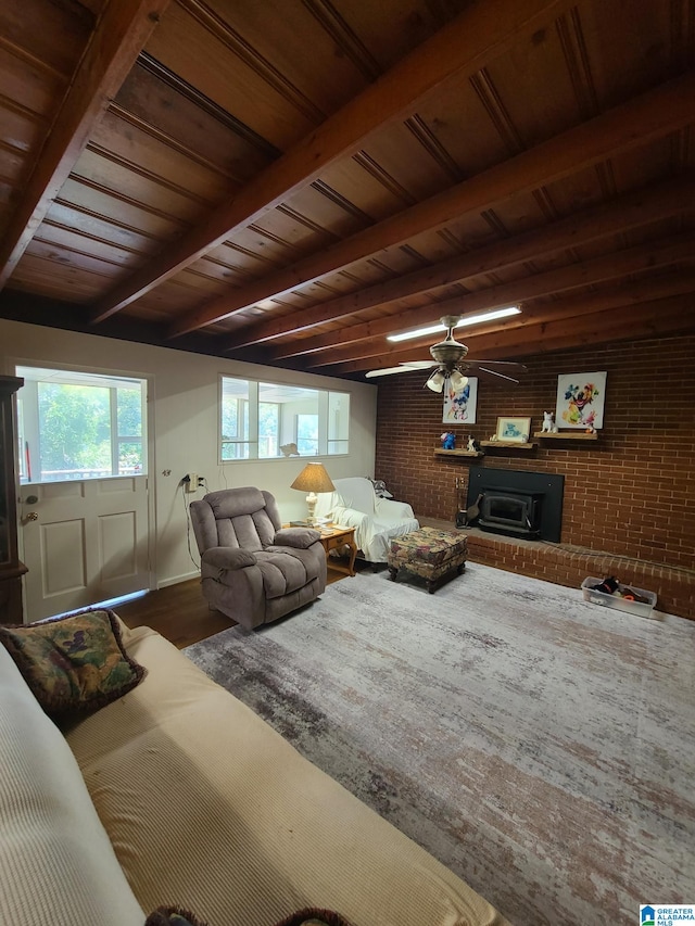 living room featuring wood ceiling, ceiling fan, beam ceiling, brick wall, and a fireplace