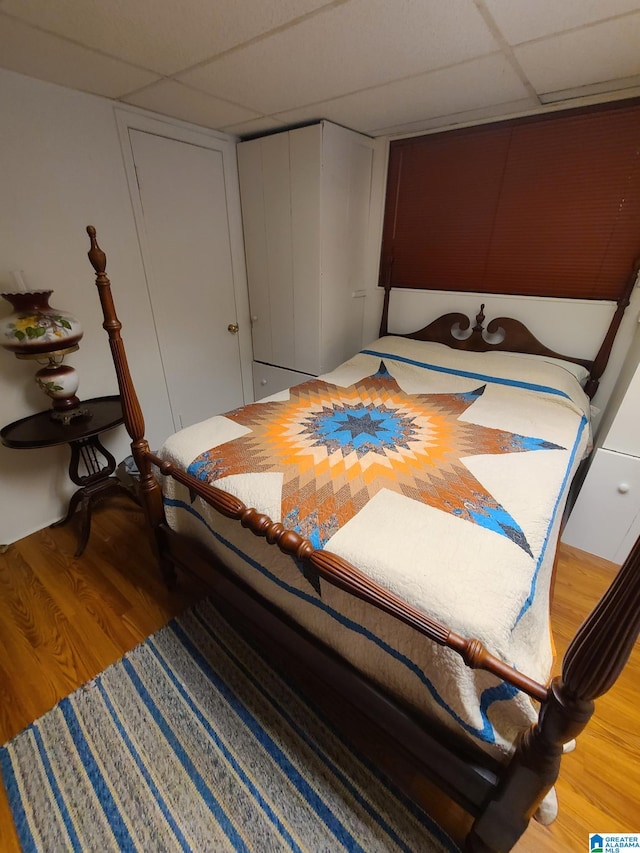 bedroom featuring light hardwood / wood-style flooring and a paneled ceiling