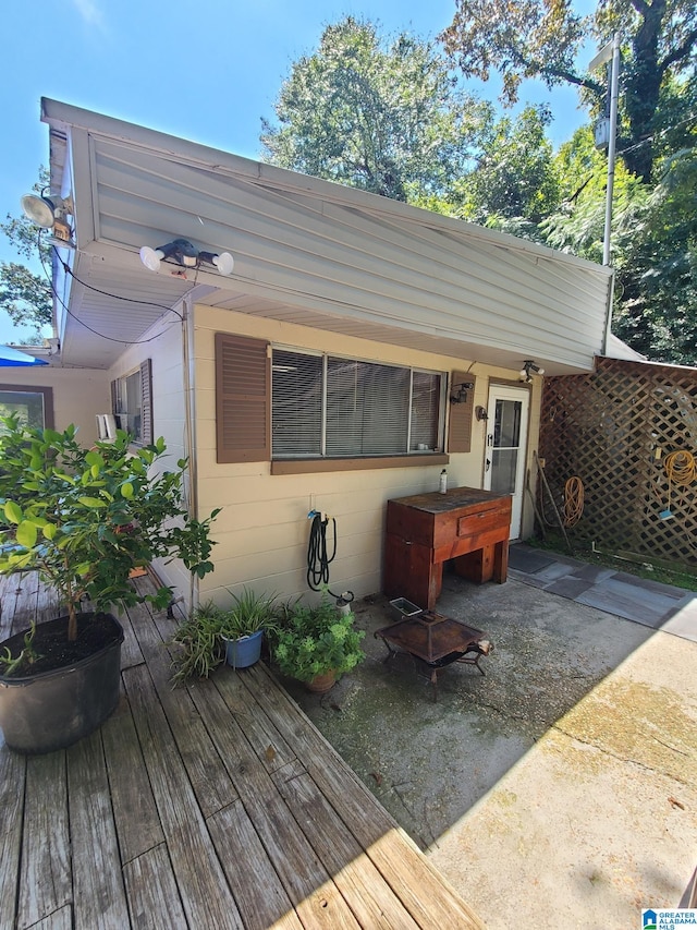 back of property featuring a wooden deck and a patio area