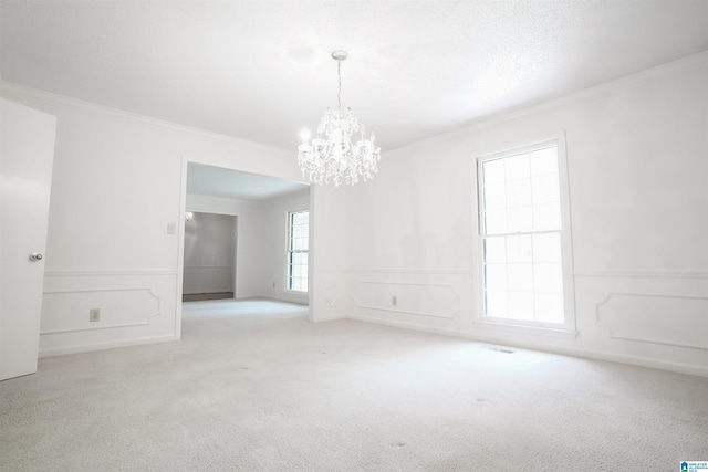 empty room featuring an inviting chandelier, light colored carpet, and a healthy amount of sunlight