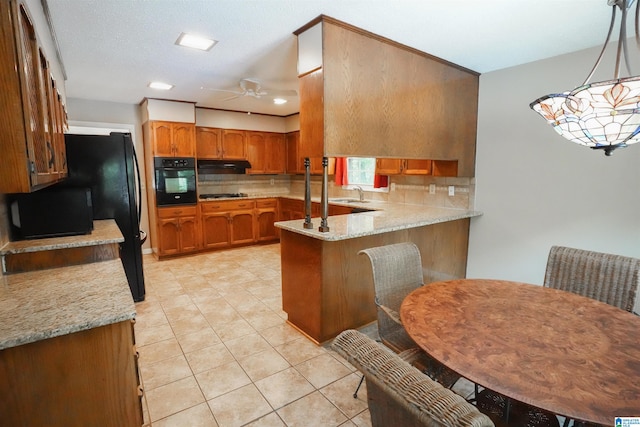 kitchen with black appliances, hanging light fixtures, light stone countertops, backsplash, and ceiling fan