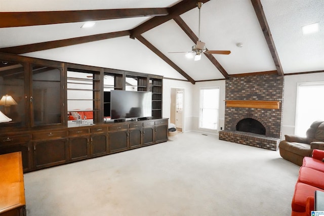 carpeted living room with high vaulted ceiling, ceiling fan, beam ceiling, a fireplace, and brick wall