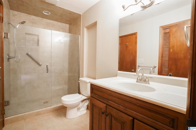 bathroom with a shower with door, vanity, tile patterned flooring, and toilet