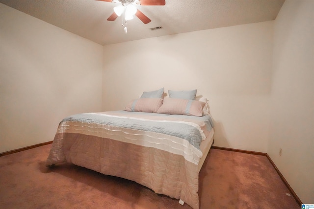 carpeted bedroom with ceiling fan and a textured ceiling