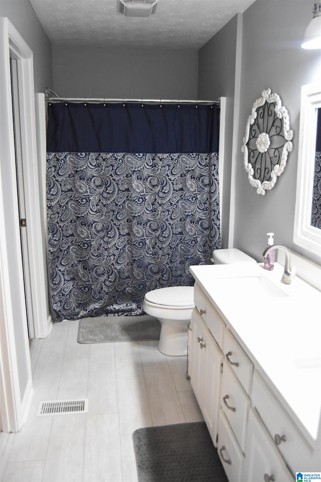 bathroom featuring vanity, toilet, and tile patterned flooring