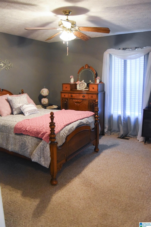 carpeted bedroom with ceiling fan and a textured ceiling