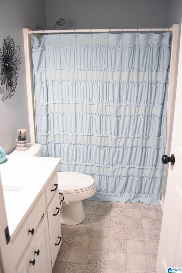 bathroom featuring toilet, vanity, and tile patterned flooring