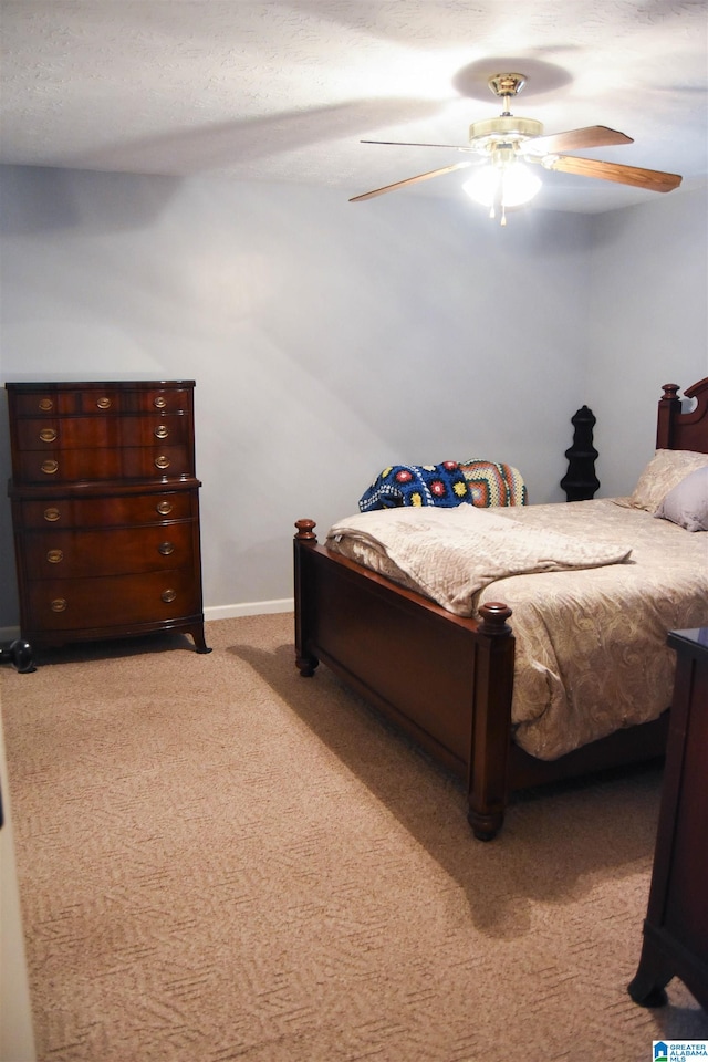 carpeted bedroom with a textured ceiling and ceiling fan