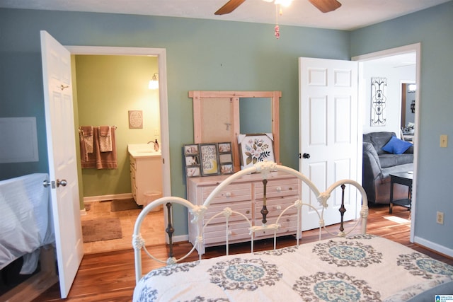 bedroom featuring ceiling fan, wood-type flooring, sink, and ensuite bath